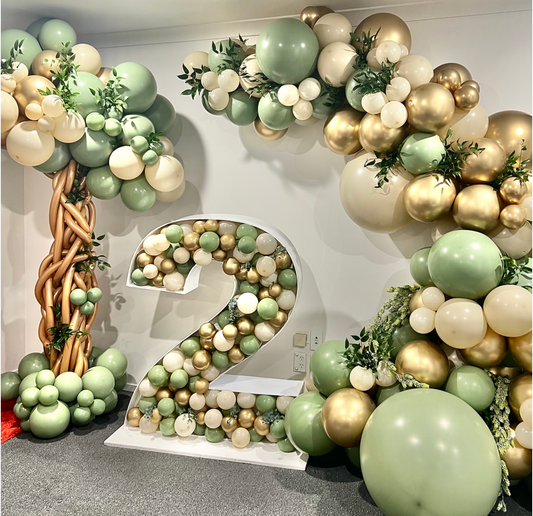 Jungle themed balloon garland and balloon mosaic number in sand and eucalyptus