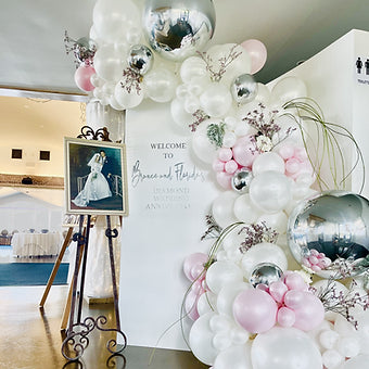 Anniversary back drop with Signage and balloon garland half arch